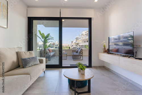 Contemporary living room with balcony access and cozy neutral sofa