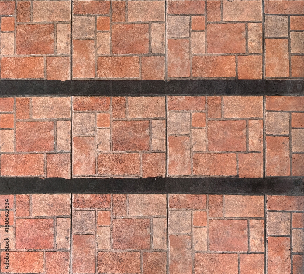 Obraz premium Close up of natural red tiles with random rectangular and square pattern, with black stripes. Geometric random size rectangular red tiles made of clay and stone. Seamless background texture.