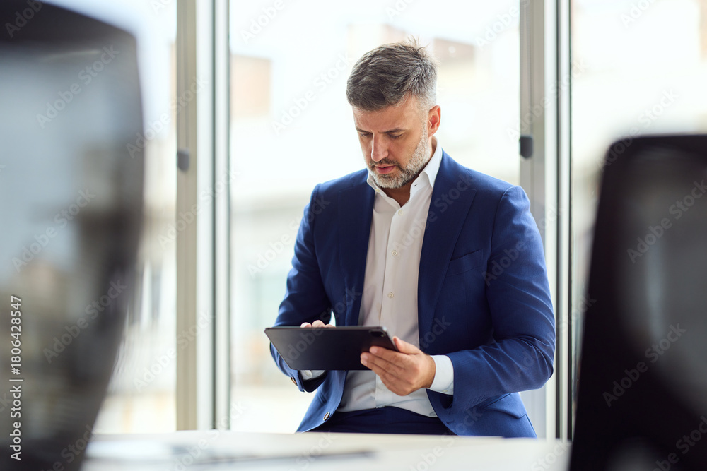 Fototapeta premium Business Professional Using Tablet In Modern Office By Window, Focused On Work