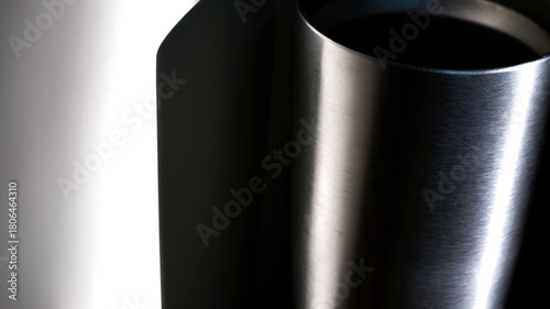 Stainless steel texture of tumbler and cabinet with dark shadow. Texture background abstract. Still-life, blurred, realistic, surface, metal, gray, natural light concept for backdrop, print, web. 