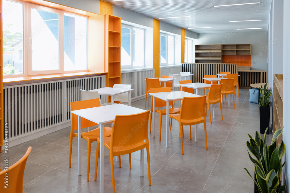 Fototapeta premium Bright and modern dining area with orange chairs in a spacious setting