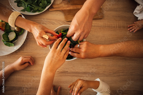 Wallpaper Mural Diverse hands of adults and children reaching for fresh salad ingredients in a bowl on a wooden table, showcasing family bonding and healthy eating habits Torontodigital.ca