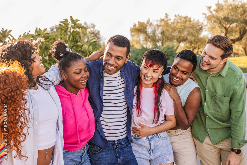 Fototapeta premium Diverse smiling young adults embracing outdoors together