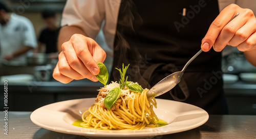 Chef plating pasta in a restaurant