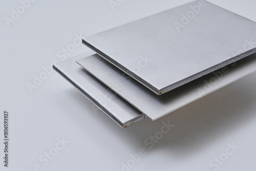High quality close up image of stainless steel metal bars and flat sections with smooth industrial texture, suitable for construction, engineering, manufacturing, and industrial design concepts.