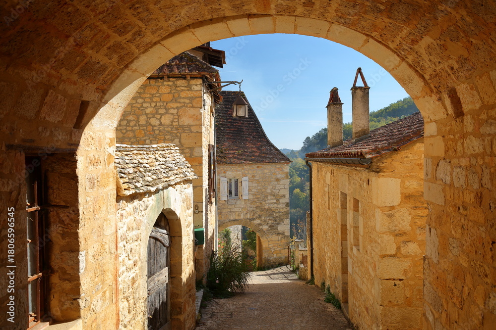 Fototapeta premium The village Castelnaud, Dordogne, France, located on a hill, with traditional medieval houses (with sloping slate roofs) and arcades