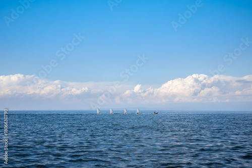 Obraz na plátně minimalist seascape with line of small training sailboats following instructor