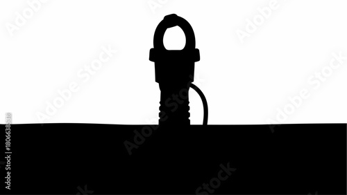 Silhouette of a threaded metal fastener with a loop sitting on a dark horizontal surface below it