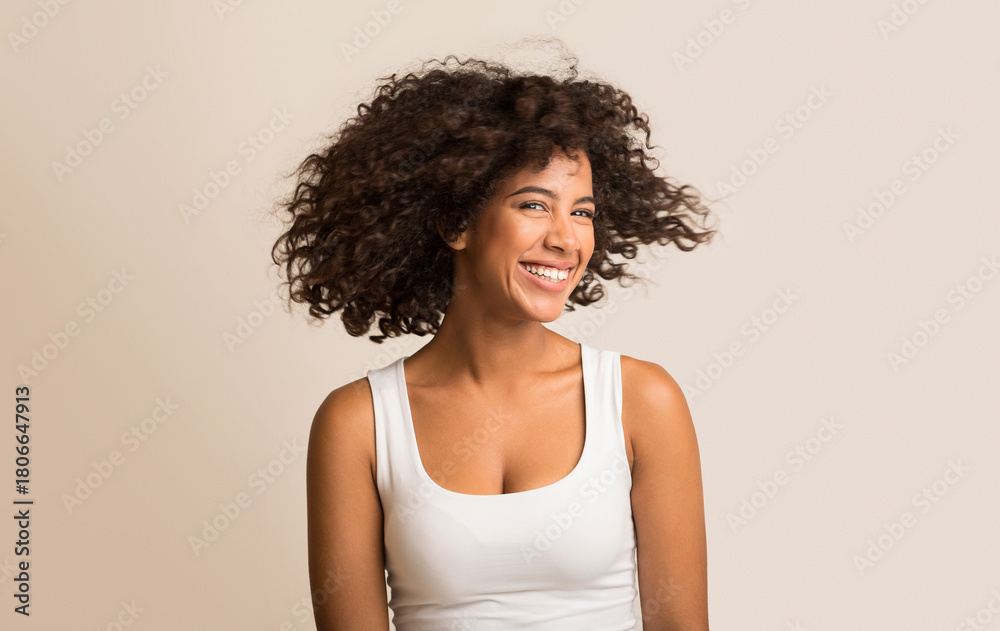 © Prostock-studio - African american woman fooling with her curly hair on light background © Prostock-studio - African american woman fooling with her curly hair on light background