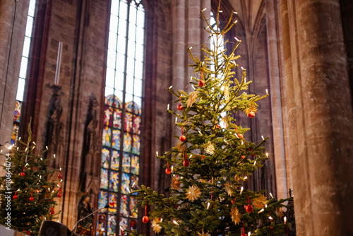 Christmas Tree and Advent Decorations Inside a European Church with Straw Ornaments, Candles, and Warm Holiday Light
