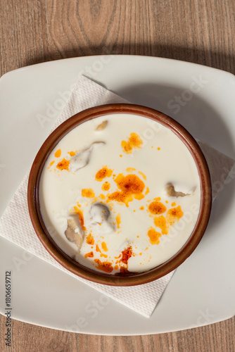 Traditional Bosnian dumplings — klepe. The dish served with a yoghurt sauce and spices on a wooden table