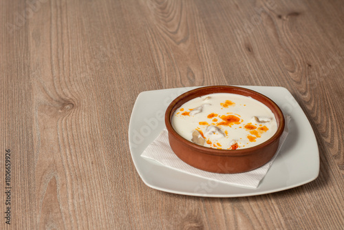Traditional Bosnian dumplings — klepe. The dish served with a yoghurt sauce and spices on a wooden table