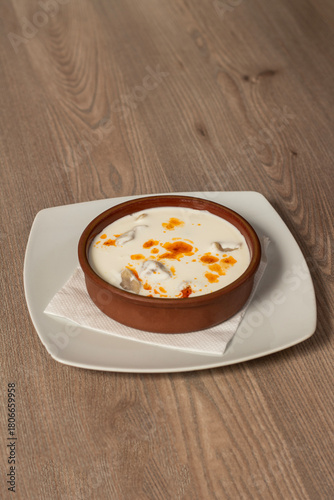 Traditional Bosnian dumplings — klepe. The dish served with a yoghurt sauce and spices on a wooden table