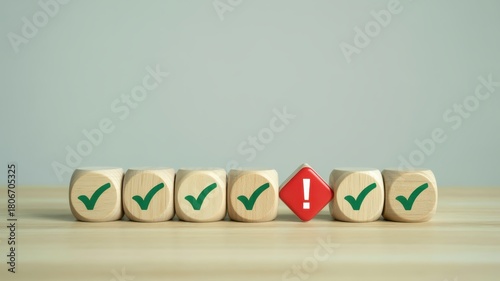Row of wooden cubes featuring green confirmation marks and one red warning sign presents a concept of error correction