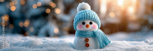 A small snowman wearing a blue knitted scarf and hat, banner