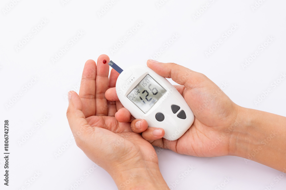 Fototapeta premium Woman's hands checking diabetes and hyperglycemia with digital blood sugar meter. Healthcare and medical concept 