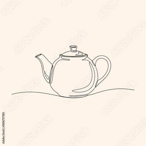 A simple teapot with a curved spout and handle sits on a surface isolated on