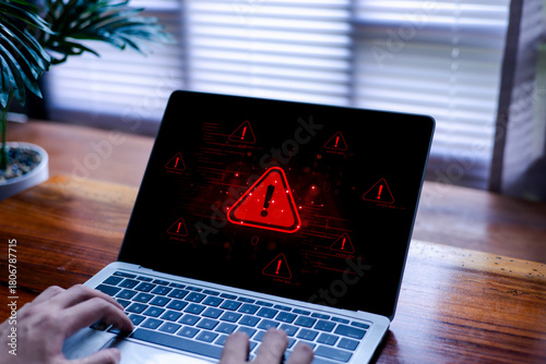 A laptop displaying a red cybersecurity alert symbol, representing system warning, malware threat detection, data security risks, and digital protection issues in a modern technology environment.