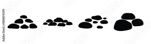 Black smooth pebbles stacked in various small piles on white