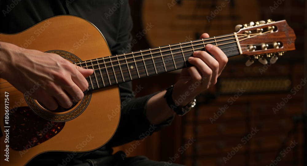 Fototapeta premium Close up of musician hands playing acoustic guitar. Male guitarist practicing chords on wooden instrument. Music performance concept