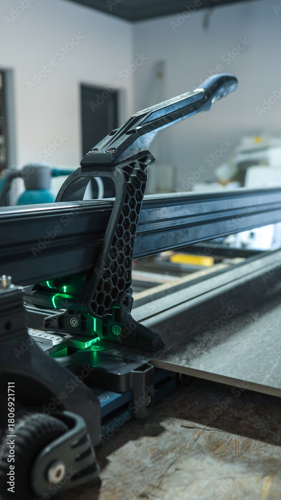 Fototapeta premium Close-up of a tile cutter with a focus on the cutting blade and handle