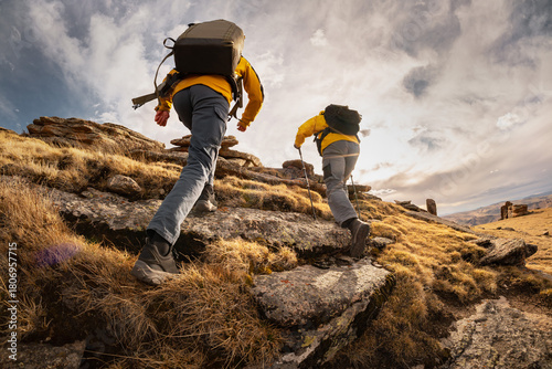 Two active male hikers guys goes uphill in mountains. Active tourism and hiking concept