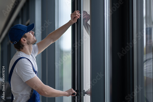 Male installer securing hinges and hardware on glass door