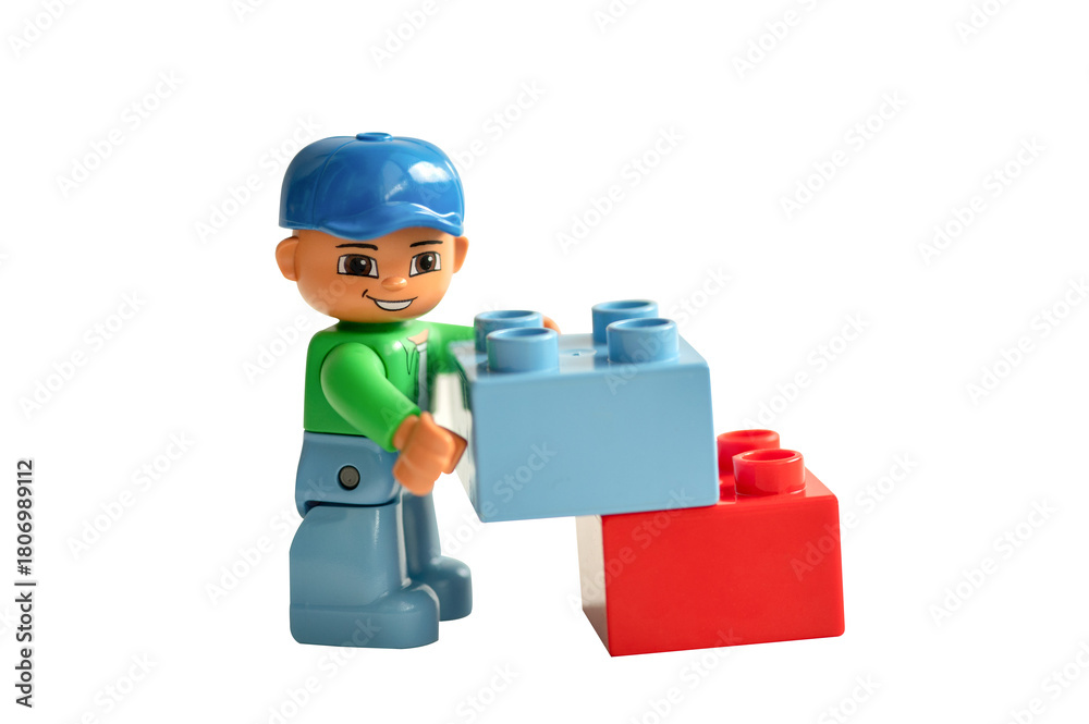 Naklejka premium Lego minifigure holds toy blocks isolated on a white background.