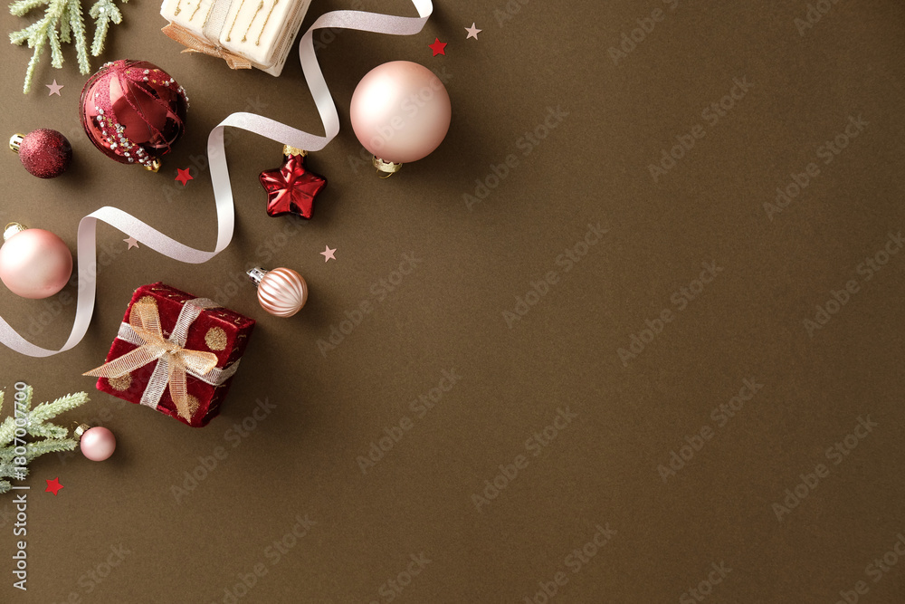 Fototapeta premium Flat lay of elegant Christmas decorations with ribbon on brown background