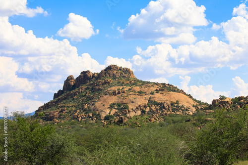 Scattered brown sandstone and rugged rock formations against a blue sky. Photographed in the Waterberg region. Panoramic view of the sandstone cliffs of the Waterberg. Namibia, Africa.