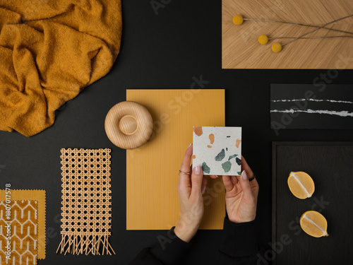 Fototapeta Naklejka Na Ścianę i Meble -  Modern material composition with mustard yellow, black, and wood elements, featuring terrazzo and woven rattan details.