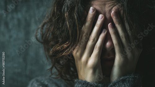 A sorrowful woman hides her face weeping amid grief and despair