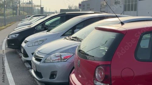 park and ride at train station with cars parking in a row in Austria