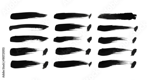 A collection of black brush strokes with varying thickness and texture, resembling ink splatters or artistic paint marks.