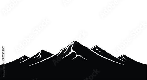 Dramatic silhouette of jagged mountain peaks against a bright sky, symbolizing adventure and natural grandeur.