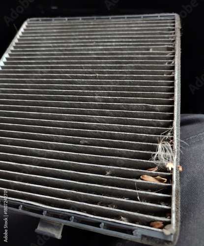 Dirty cabin air filter being replaced in a car.