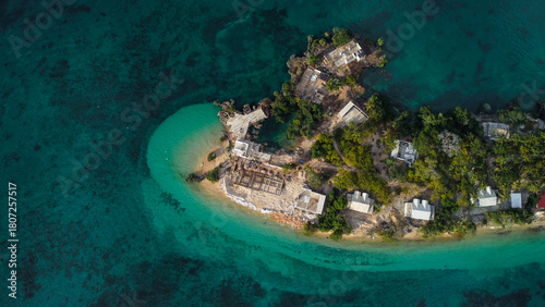 Fotografie An aerial view of a secluded tropical island or peninsula, featuring white build