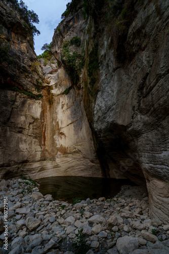 Rock amphitheater and plunge pool beneath towering cliffs