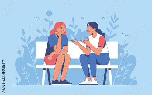 Two women engage in conversation while sitting on a park bench amidst decorative foliage.