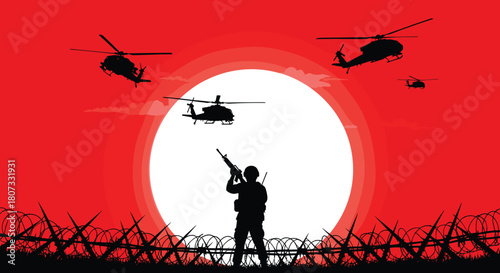 Silhouette of military soldier with rifle standing behind barbed wire with helicopters flying against red sunset background