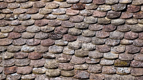 Old tiles on the roof. A tile made of clay on the house.