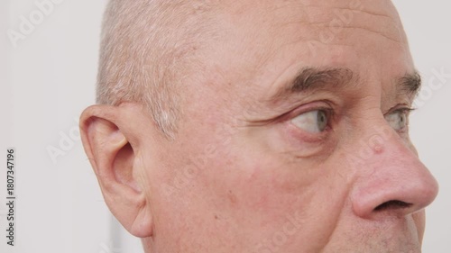 bald man hearing or listening deeply, ear with pained expression, discomfort loud noise, age-related hearing loss, Emotional portrait, discomfort loud noise, Environmental noise, reaction loud sounds