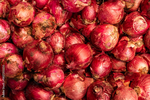 Fresh red onions displayed at a vibrant Kenyan market stall