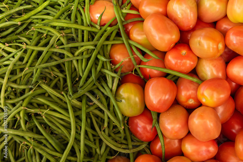 Ripe Red Juicy Tomatoes with Fresh Green French Beans at a Market Stall, showcasing tropical produce and healthy eating