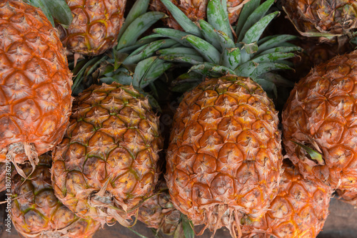 Fresh, ripe yellow pineapples displayed at a busy Kenyan market, highlighting juicy tropical fruit and vibrant market culture.