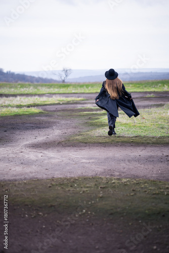 A girl walking in nature in a deserted place on a gloomy day