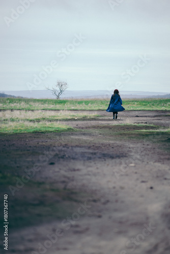 A girl walking in nature in a deserted place on a gloomy day