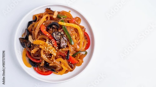 Korean Japchae dish served on a white ceramic plate placed on a wooden table.