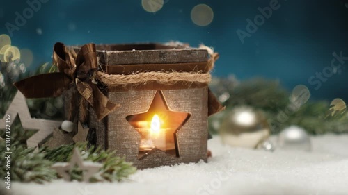 Christmas lantern candleflame with falling snow and blue background