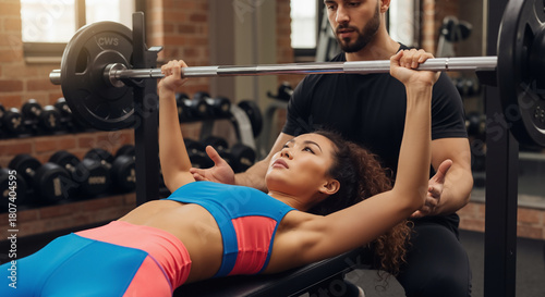 Personal Trainer Spotting Woman Bench Pressing Heavy Weights